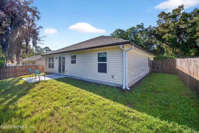 a view of a house with a backyard and a patio