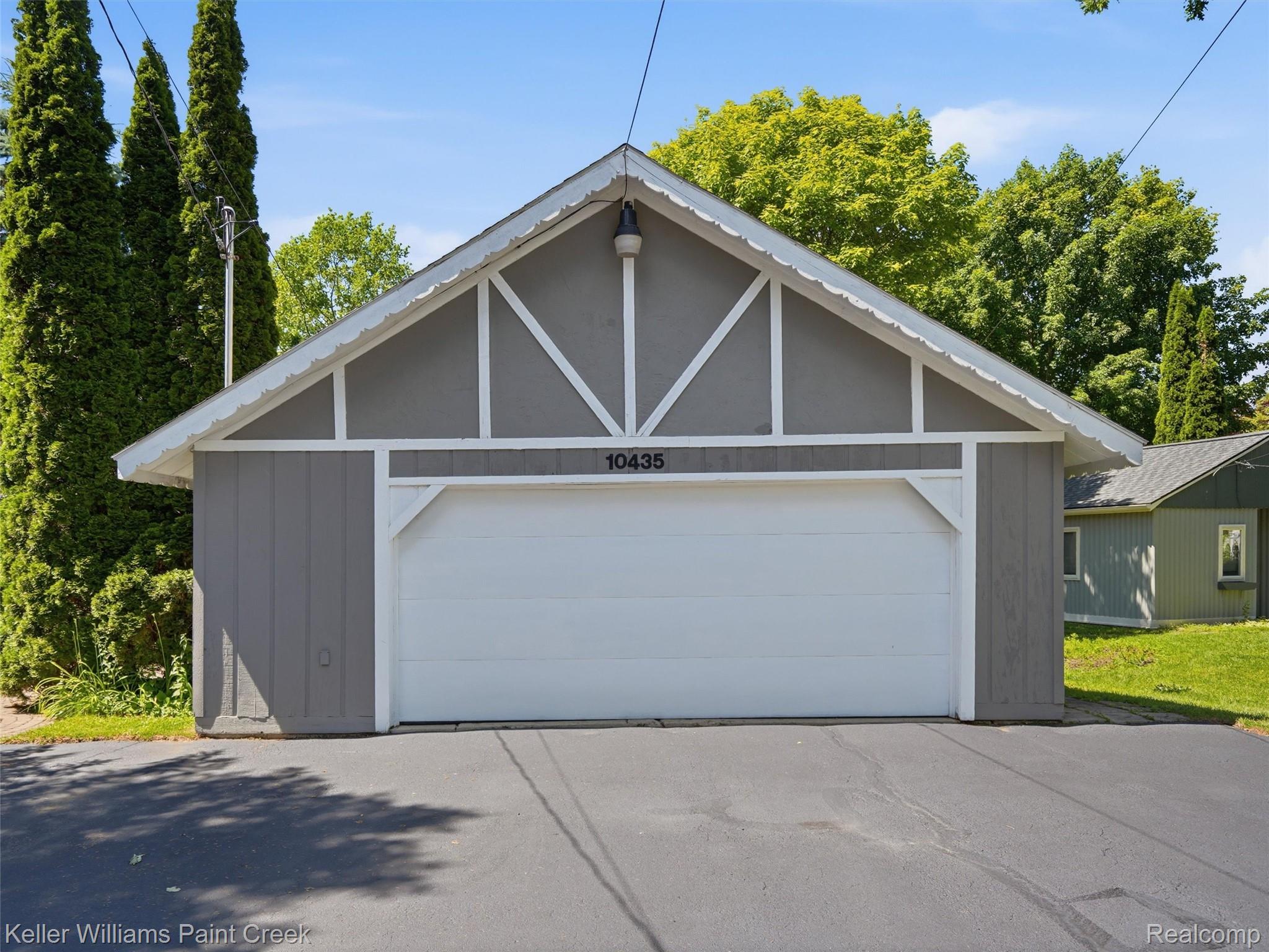 10435 Spring Street Fenton, MI 48430 - Photo 37 of 40 Single-car garage with a gabled roofline and white trim accents