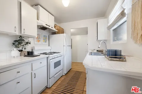 a kitchen with stainless steel appliances a sink stove and cabinets