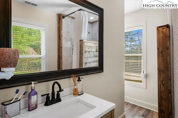 a bathroom with a sink a mirror and a window