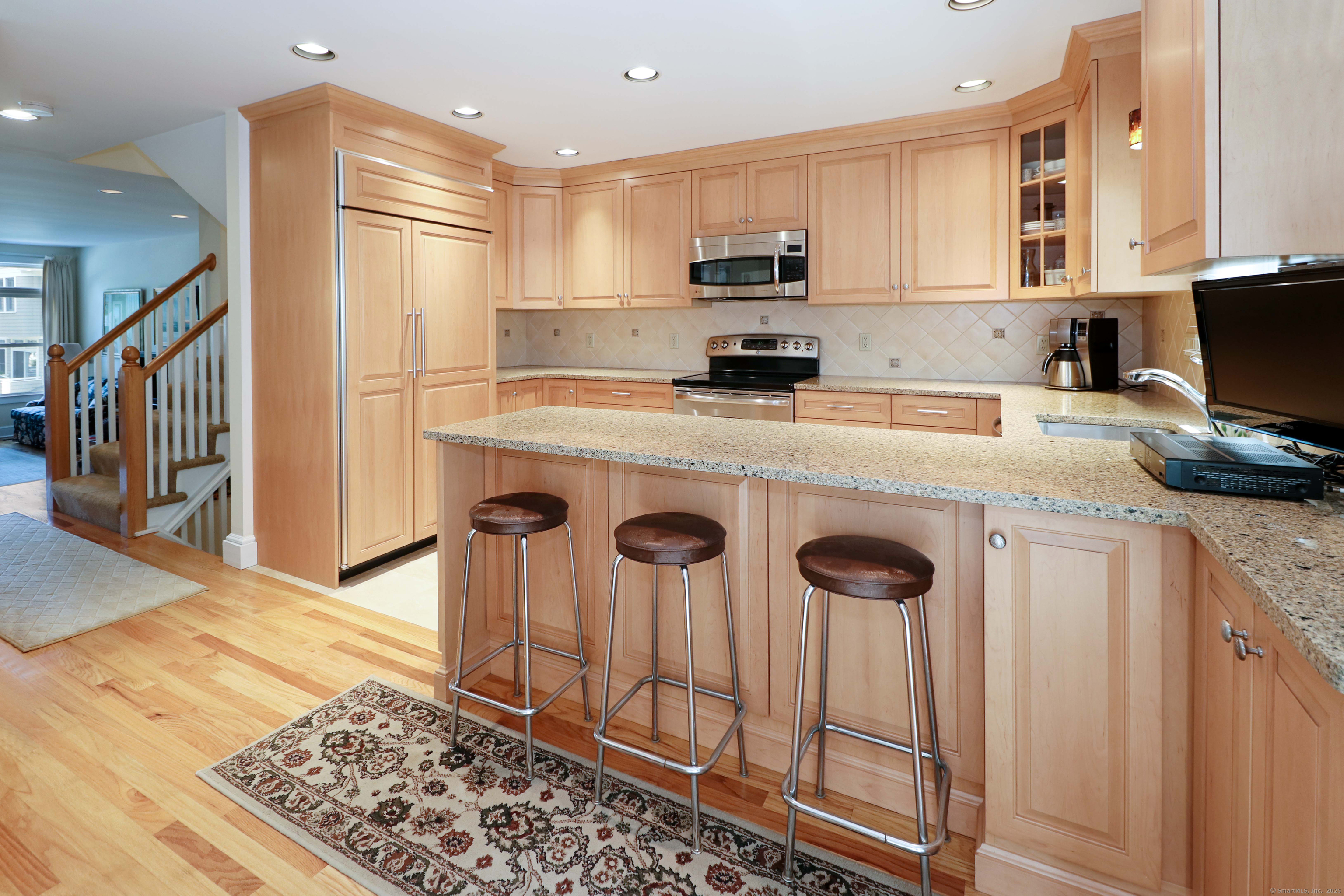 972 South Pine Creek Road, Unit 972 Fairfield, CT 06824 - Photo 11 of 37 a kitchen with stainless steel appliances a stove a refrigerator and cabinets