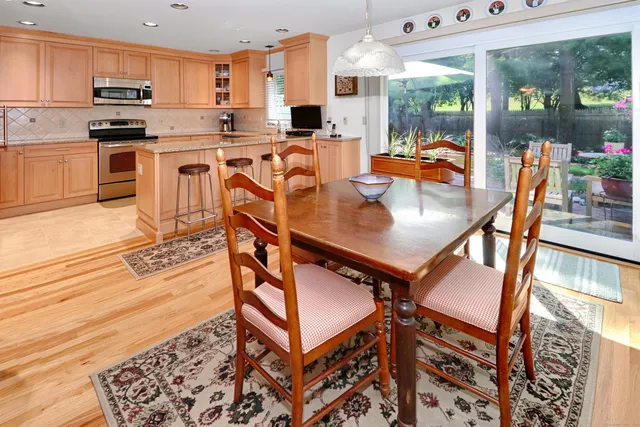 a open kitchen with stainless steel appliances granite countertop a stove and a view of living room