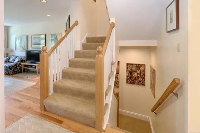 a view of staircase with lots of frames on wall
