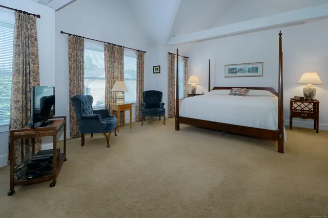 a spacious bedroom with a bed and a chandelier