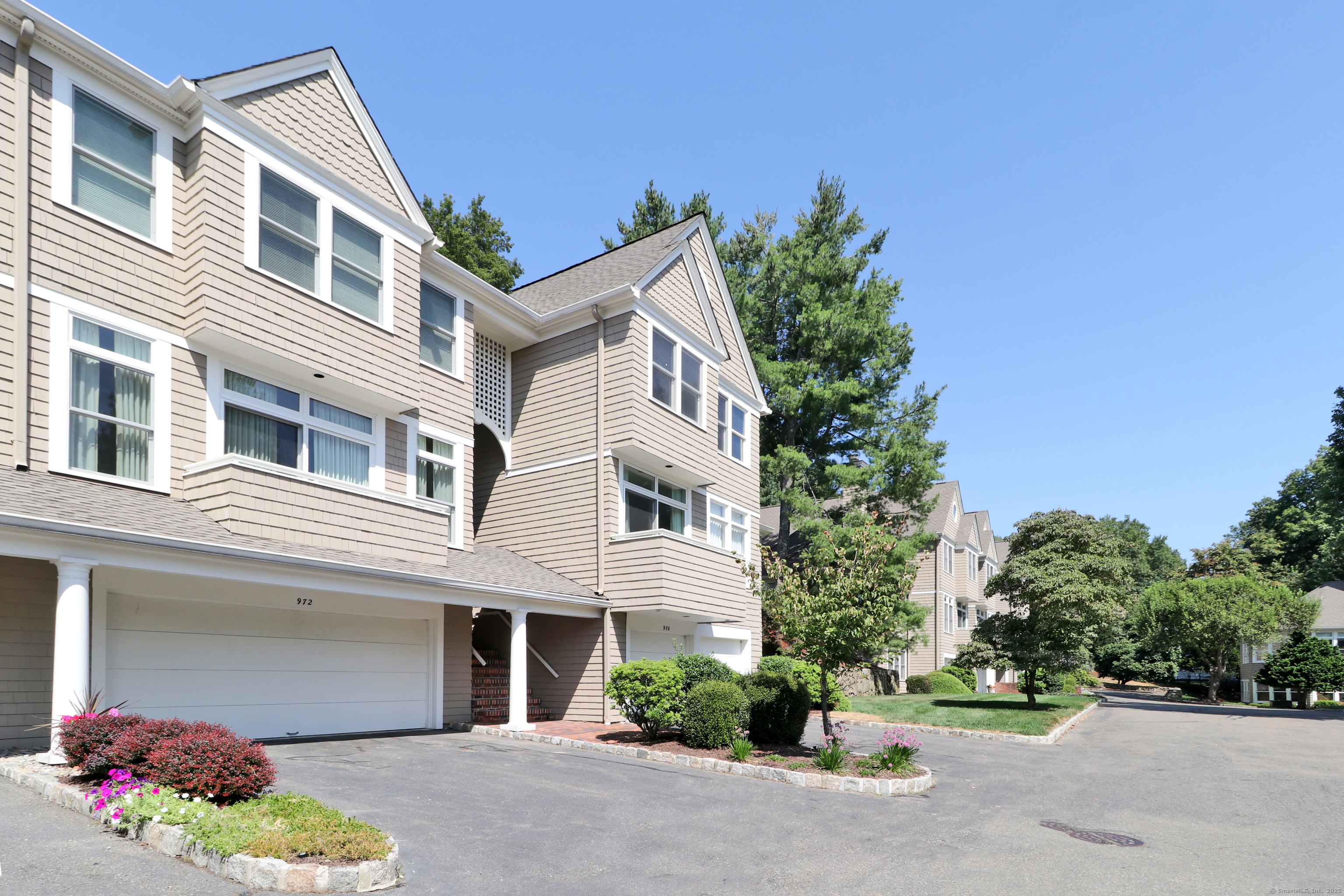 972 South Pine Creek Road, Unit 972 Fairfield, CT 06824 - Photo 2 of 37 a front view of a house with a yard