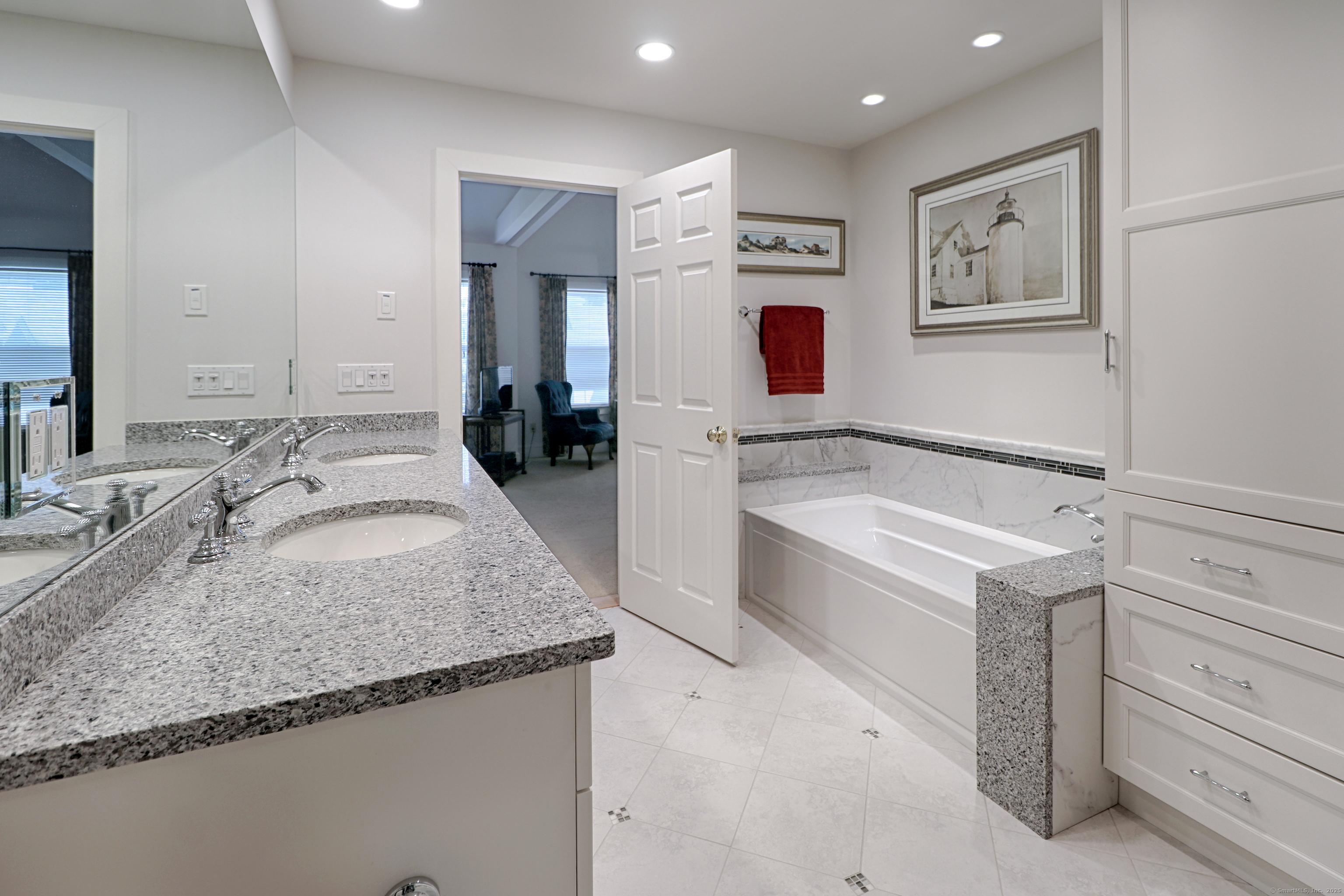 972 South Pine Creek Road, Unit 972 Fairfield, CT 06824 - Photo 22 of 37 a bathroom with a granite countertop tub sink and mirror