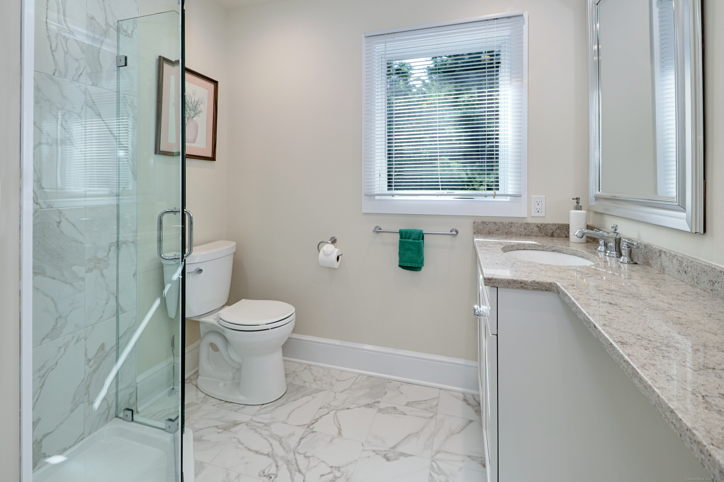 972 South Pine Creek Road, Unit 972 Fairfield, CT 06824 - Photo 25 of 37 a bathroom with a granite countertop toilet a sink and a shower