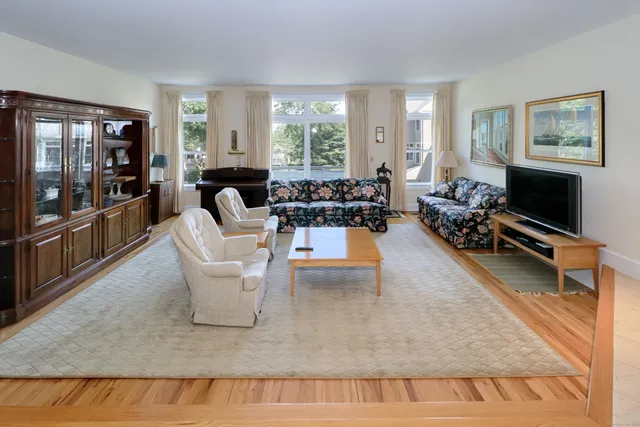 a living room with furniture a large window and flat screen tv