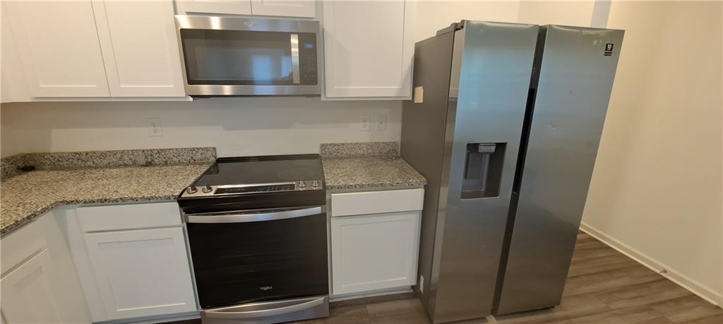 1683 Vernon Boulevard Decatur, GA 30035 - Photo 4 of 14 a kitchen with stainless steel appliances white cabinets and a granite counter top