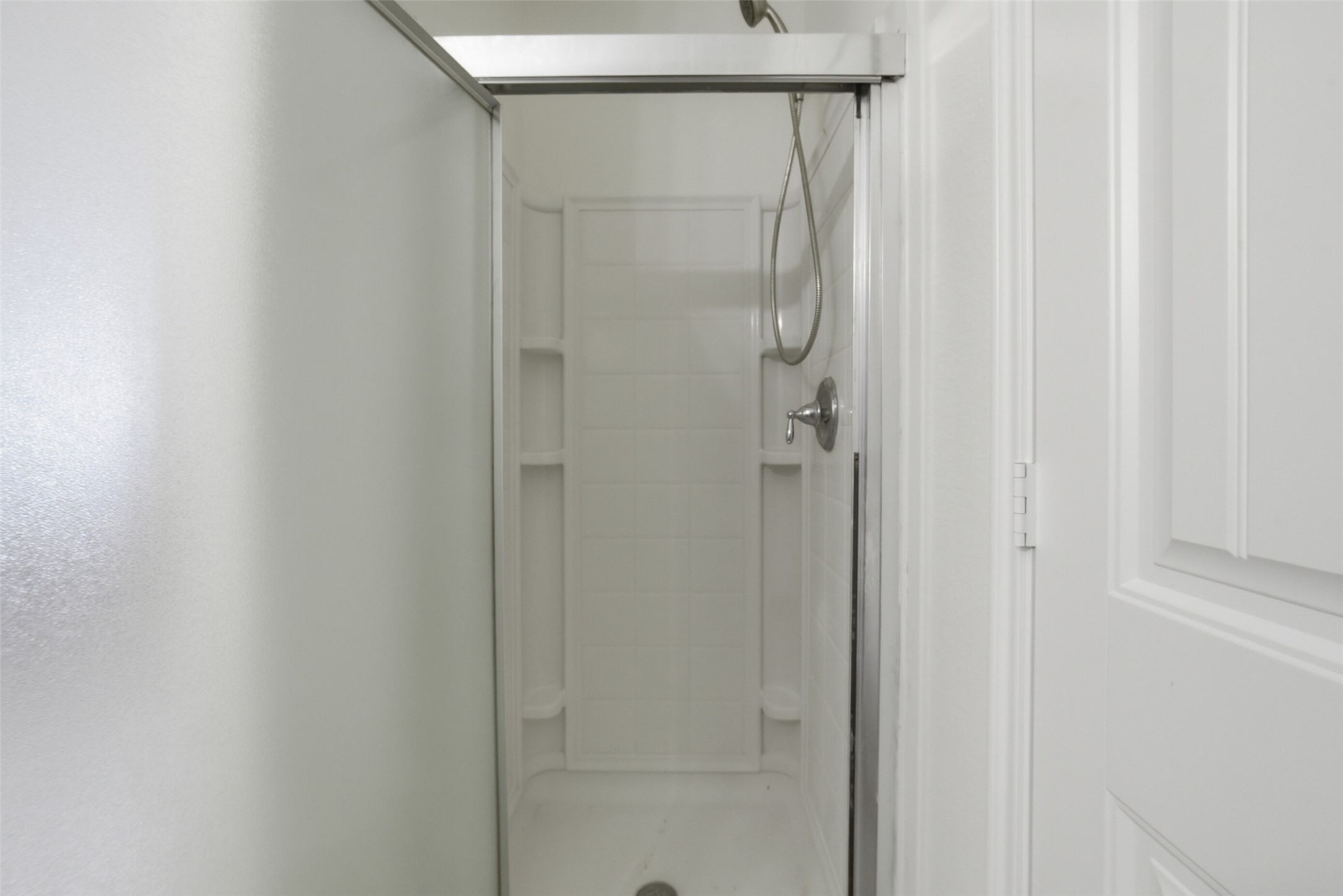 12830 Spruce Circle Tomball, TX 77375 - Photo 26 of 39 The primary bathroom has an
enclosed shower with a glass
door, white tiles, and a sleek
shower head, offering a clean
and functional bathing space.