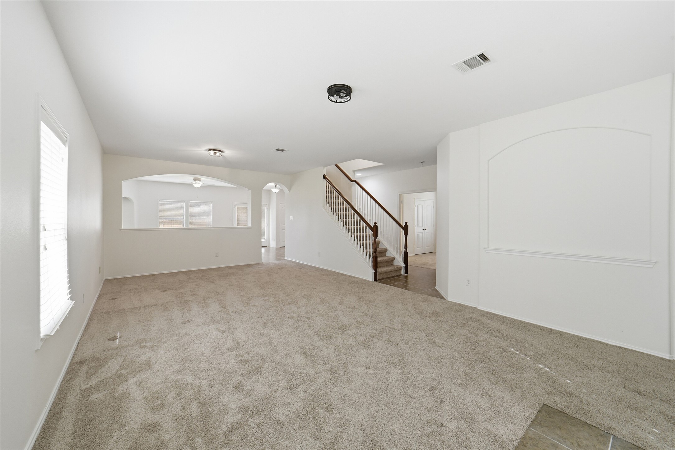12830 Spruce Circle Tomball, TX 77375 - Photo 4 of 39 This spacious living area
features brand new neutral
carpeting, multiple windows
providing ample natural light
and a view into the adjacent
dining area. The room leads to
the freshly carpeted staircase
that features wooden railings
and balusters.