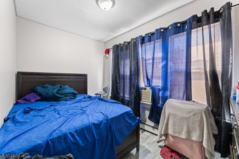 907 Flora Street Elizabeth, NJ 07201 - Photo 19 of 24 a bedroom with a bed and a mirror