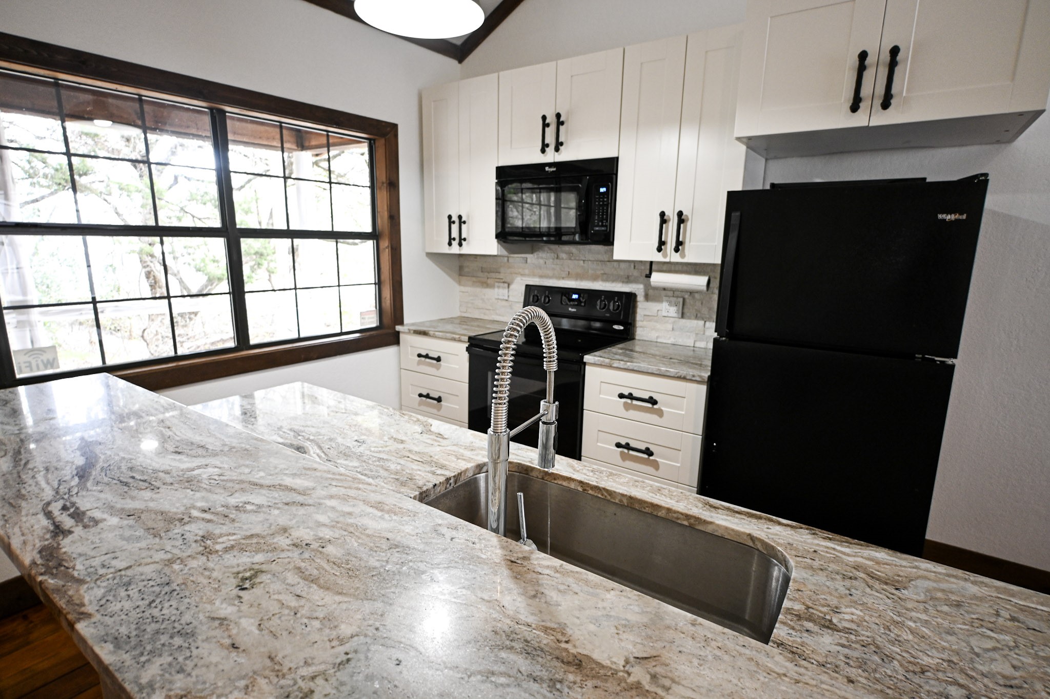 15104 Texas Street Austin, TX 78734 - Photo 5 of 18 a kitchen with a refrigerator and a stove top oven