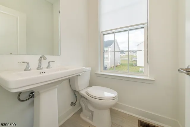a bathroom with a sink a toilet and a window