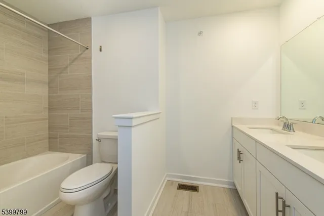 a bathroom with a granite countertop sink a toilet and shower