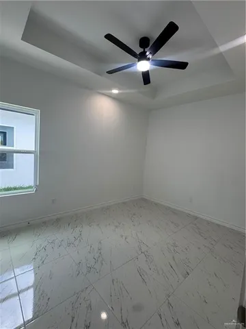 an empty room with a ceiling fan and window
