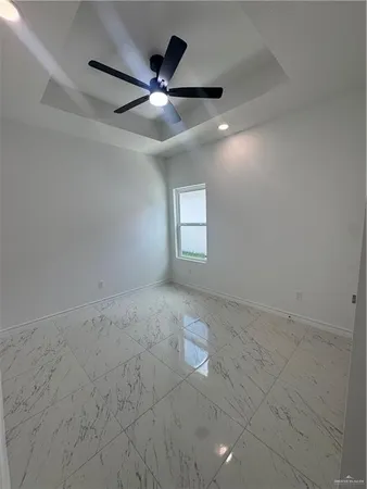 an empty room with windows and fan