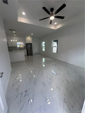 a view of a livingroom with a ceiling fan and window