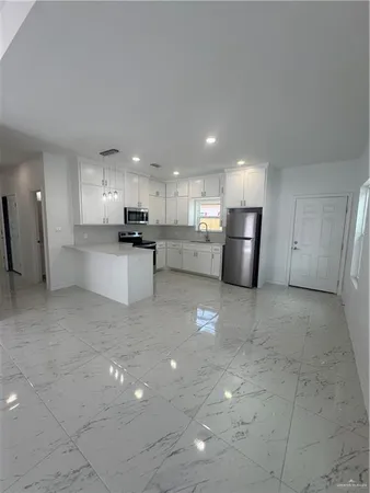 a kitchen with stainless steel appliances a refrigerator sink and cabinets