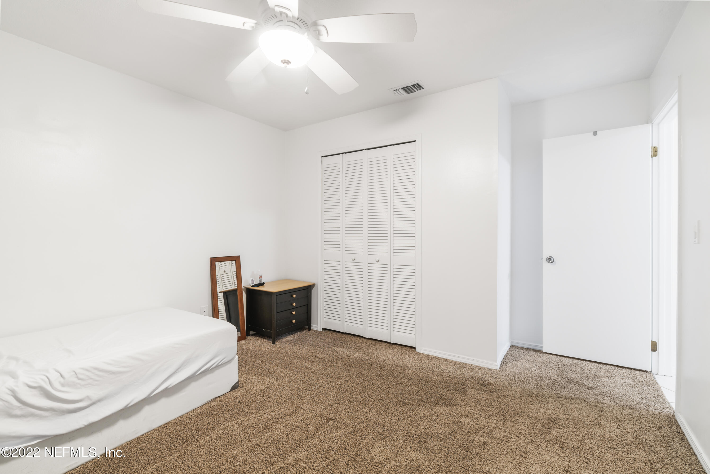 288 West Shores Road Fleming Island, FL 32003 - Photo 10 of 36 a bedroom with a bed and a chandelier
