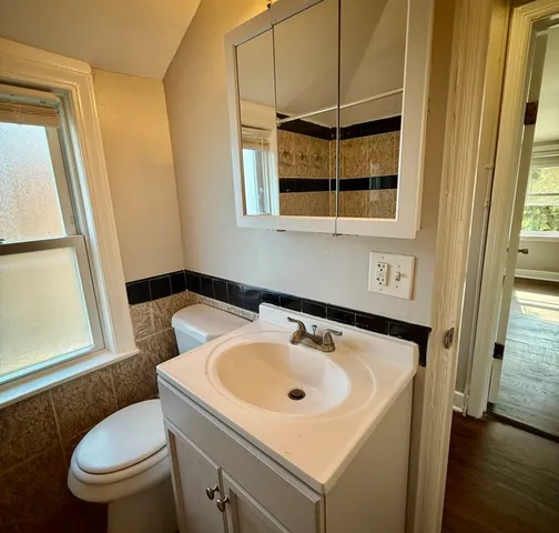 a bathroom with a sink a toilet and a mirror