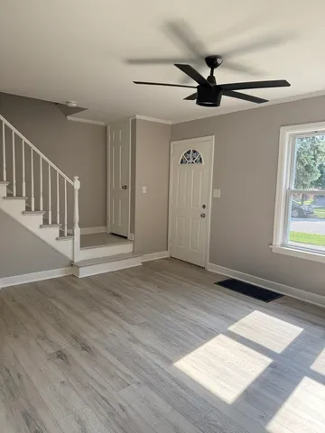 a view of an empty room with a window and wooden floor