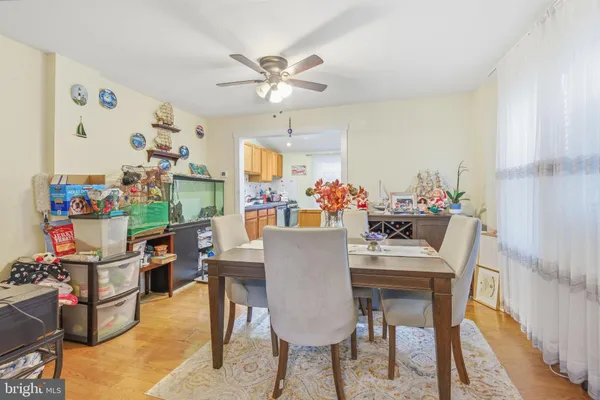 a dining room with furniture and a chandelier fan