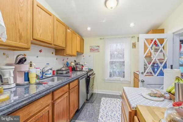 a kitchen with stainless steel appliances granite countertop a sink dishwasher cabinets and next to a window