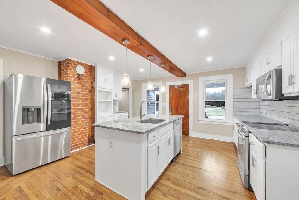 1385 Lyon Street Ludlow, MA 01056 - Photo 5 of 35 a large kitchen with stainless steel appliances granite countertop a large counter top a stove and a refrigerator
