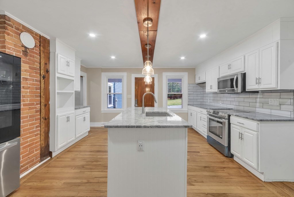 1385 Lyon Street Ludlow, MA 01056 - Photo 6 of 35 a large kitchen with stainless steel appliances kitchen island granite countertop a large counter top and sink