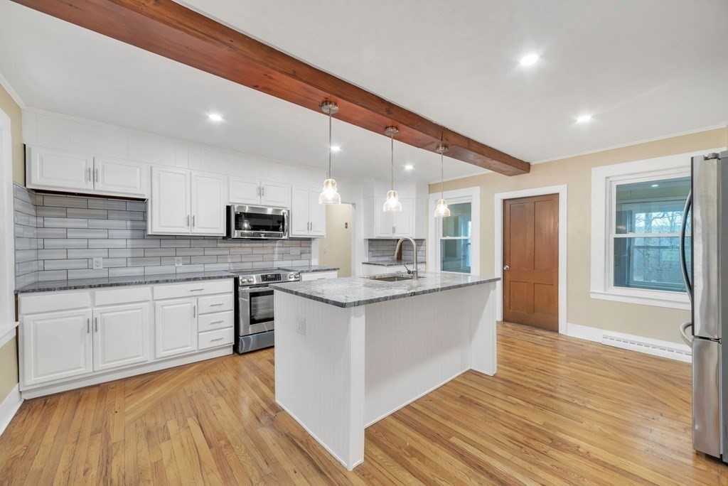 1385 Lyon Street Ludlow, MA 01056 - Photo 8 of 35 a large kitchen with stainless steel appliances granite countertop a stove and a sink