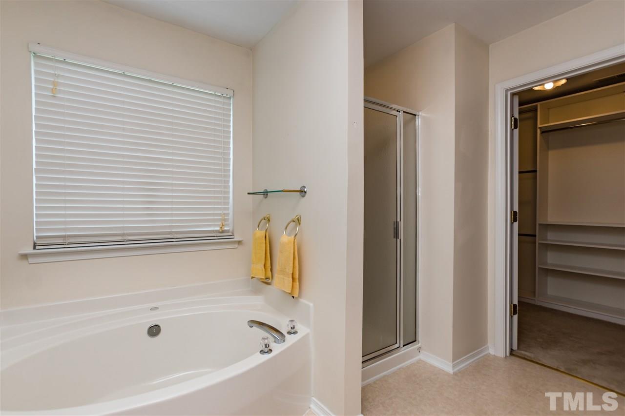 8313 Rubblestone Path Raleigh, NC 27613 - Photo 17 of 25 a white bath tub sitting next to a shower