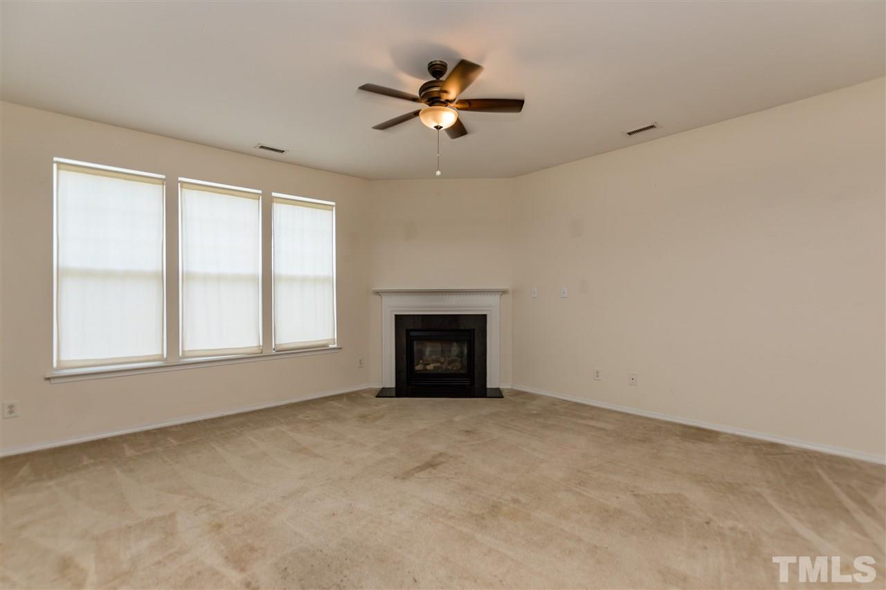 8313 Rubblestone Path Raleigh, NC 27613 - Photo 5 of 25 an empty room with a fireplace and windows