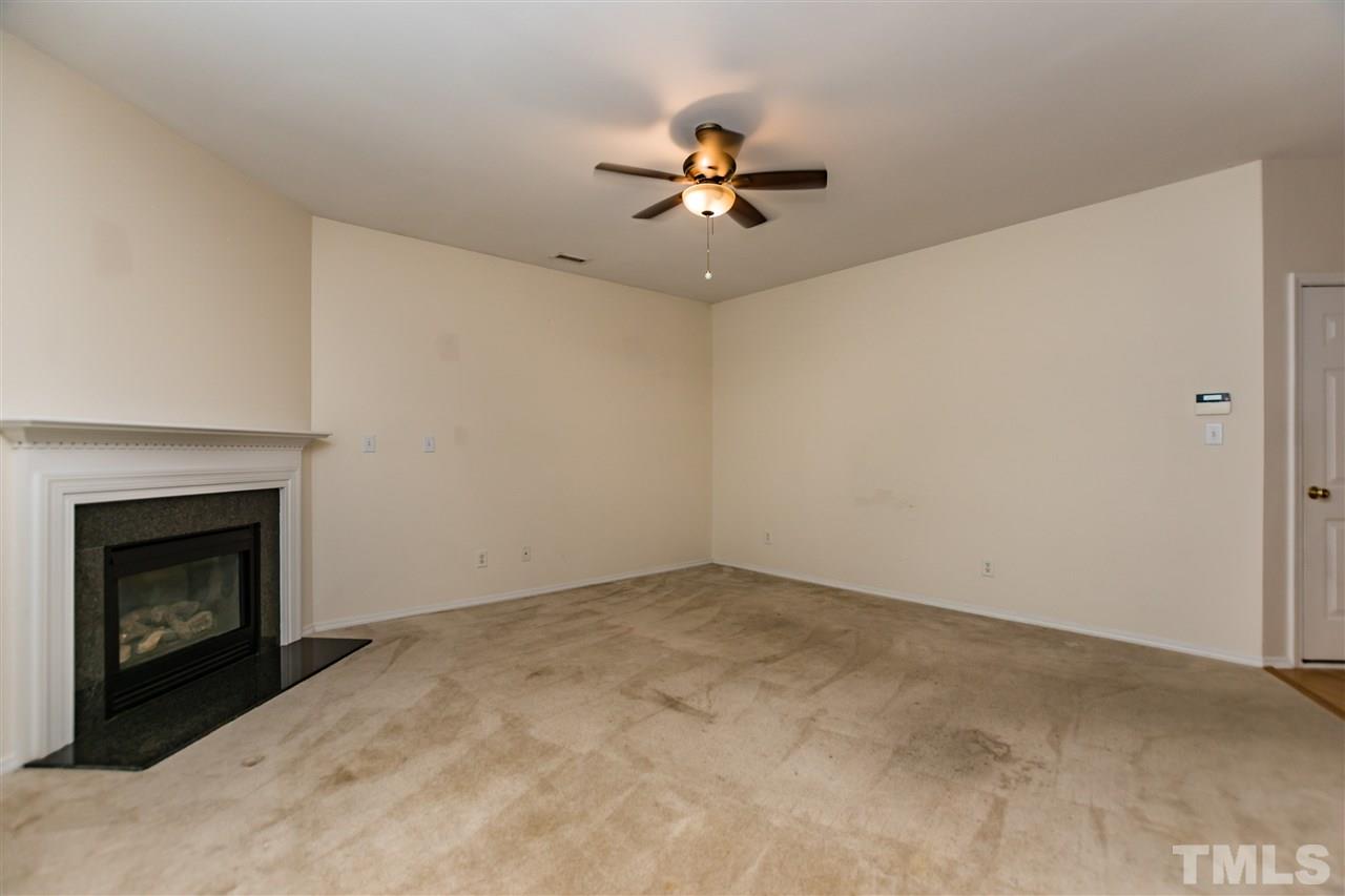 8313 Rubblestone Path Raleigh, NC 27613 - Photo 6 of 25 a view of an empty room with chandelier fan and fire place