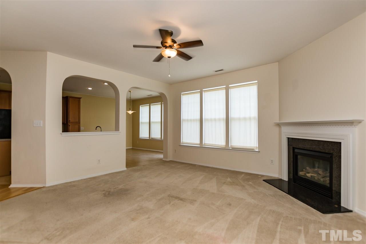 8313 Rubblestone Path Raleigh, NC 27613 - Photo 7 of 25 a view of an empty room with chandelier fan and fire place