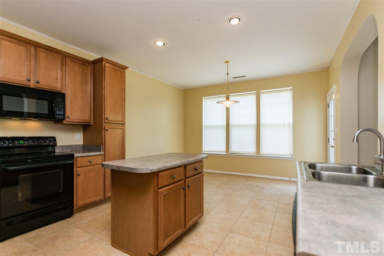 8313 Rubblestone Path Raleigh, NC 27613 - Photo 10 of 25 a kitchen with stainless steel appliances granite countertop a stove a sink and a refrigerator