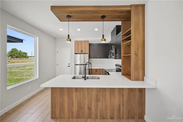 a kitchen with a sink a window and stainless steel appliances