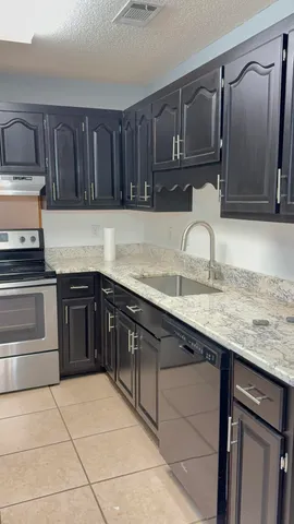 a kitchen with stainless steel appliances granite countertop a stove a sink and a microwave