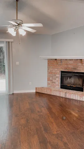 a view of an empty room with a fireplace and a window