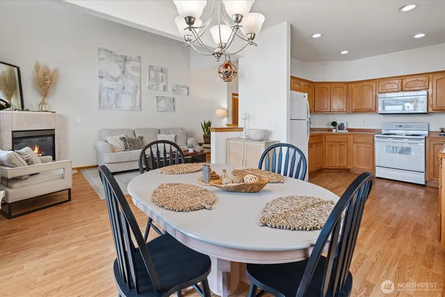 a view of a dining room with furniture a chandelier and wooden floor