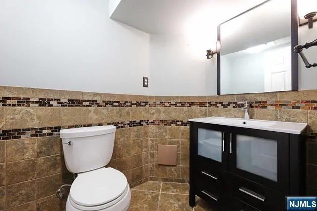 a bathroom with a granite countertop toilet sink and mirror
