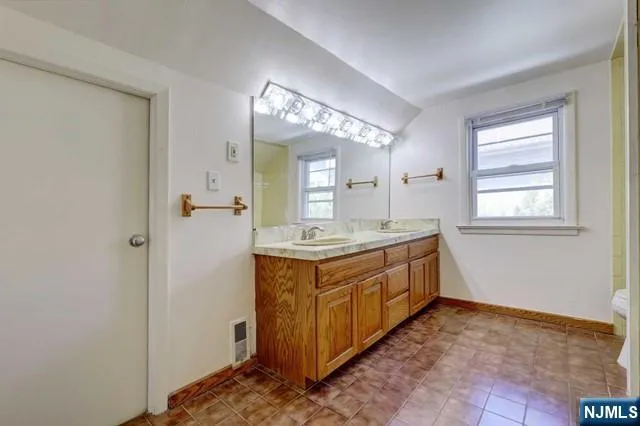 a spacious bathroom with a double vanity sink and a mirror