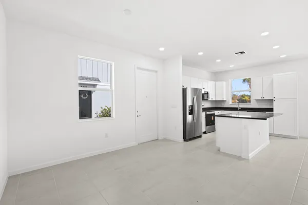 a kitchen with granite countertop stainless steel appliances a sink a counter top space and cabinets