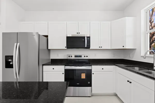 a kitchen with stainless steel appliances granite countertop a stove a sink and a refrigerator