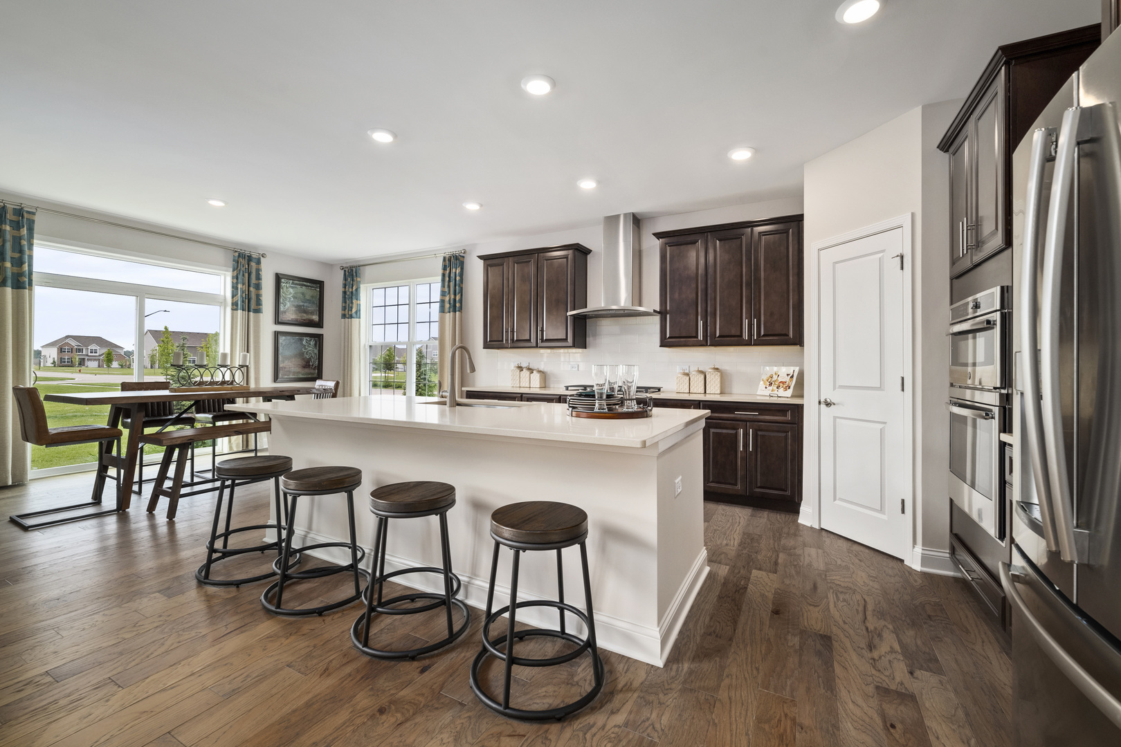 3648 Edelweiss Road Elgin, IL 60124 - Photo 11 of 32 a kitchen with stainless steel appliances granite countertop a refrigerator a microwave a stove a sink and chairs with wooden floor
