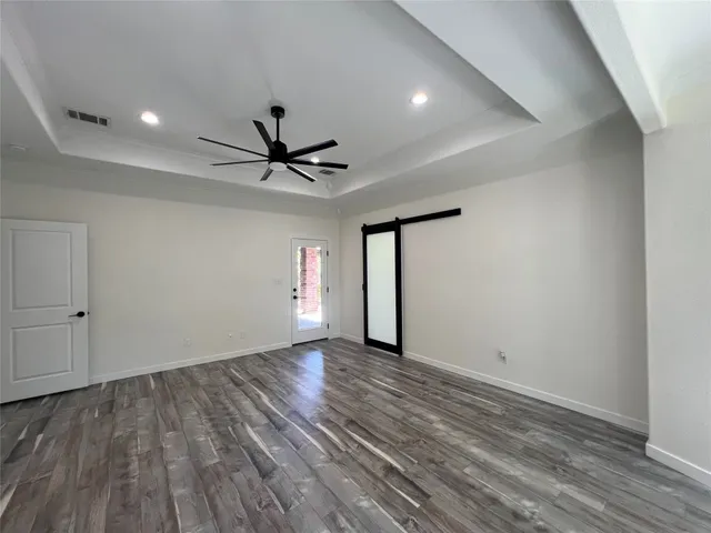 wooden floor in an empty room with a ceiling fan
