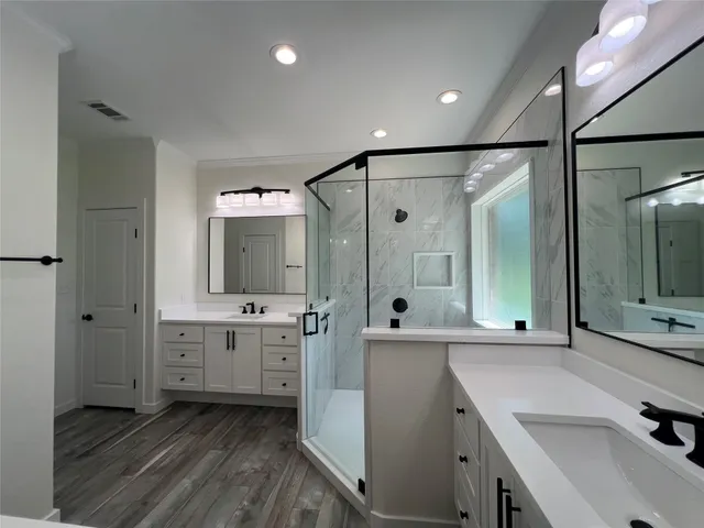 a bathroom with a double vanity sink mirror and shower
