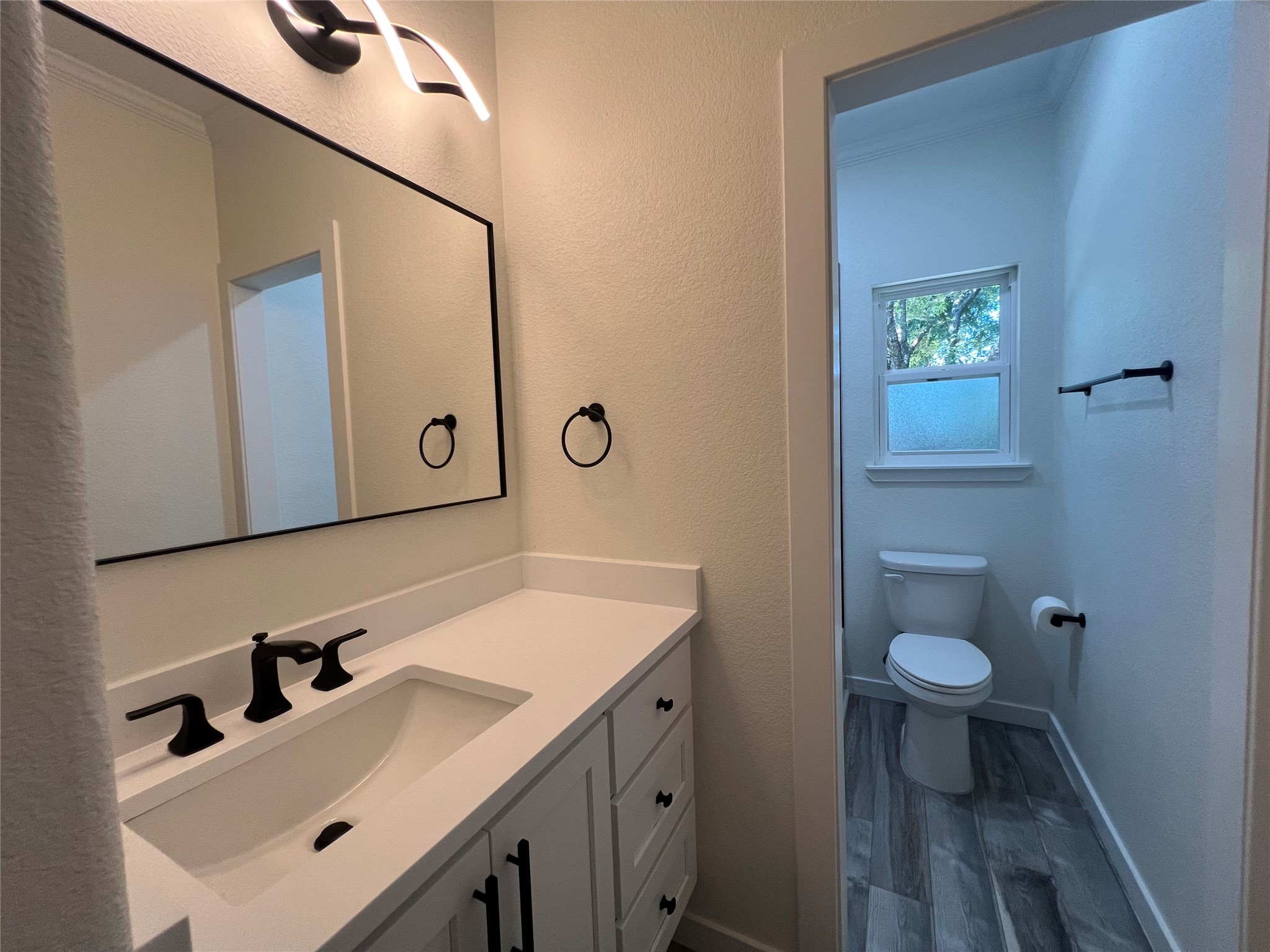 117 Cotton Rows Lane Taylor, TX 76574 - Photo 28 of 35 Jack and Jill Bathroom between the two spare bedrooms with vanity and wood finished floors