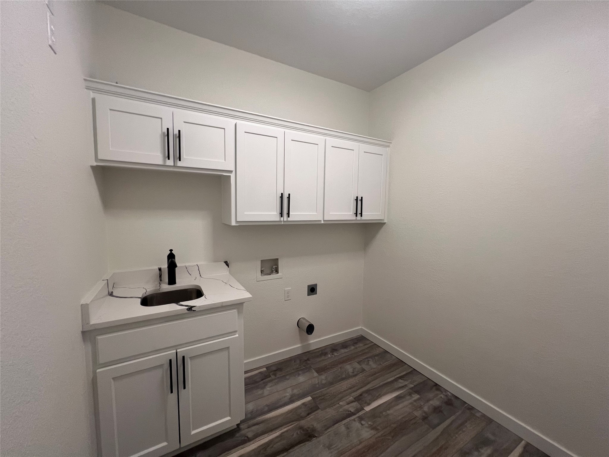 117 Cotton Rows Lane Taylor, TX 76574 - Photo 32 of 35 Laundry area featuring cabinet space, washer hookup, hookup for an electric dryer, and dark wood-style flooring