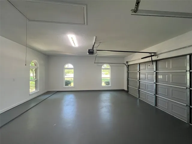 an empty room with windows and ceiling fan